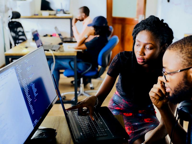 A team of developers reviewing an app together at a laptop
